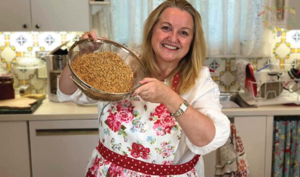 Mary's Nest in her kitchen with a bowl of sprouted grains in her hands.