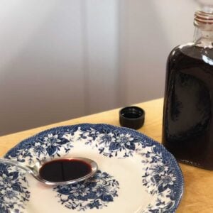 A bottle of Elderberry Syrup with spoon.