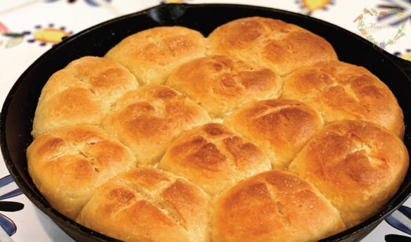 Yeast dinner rolls baked in a cast iron skillet on the table.
