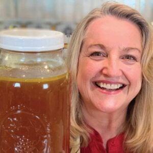 Mary holding a container of fresh turkey bone broth.