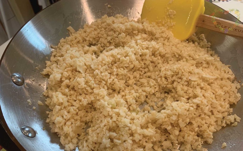 Rehydrated Cauliflower Rice in a Frying Pan with a Spatula