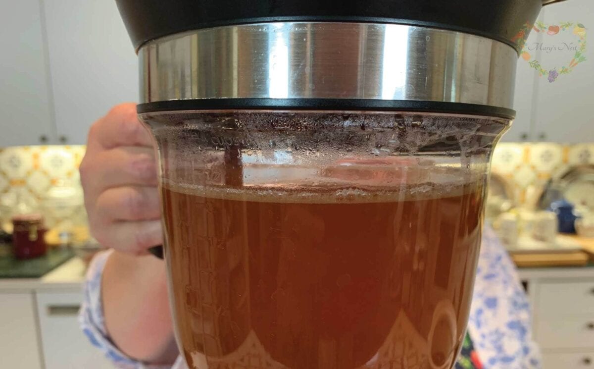 Mary using the Fat Separator device to decant bone broth.