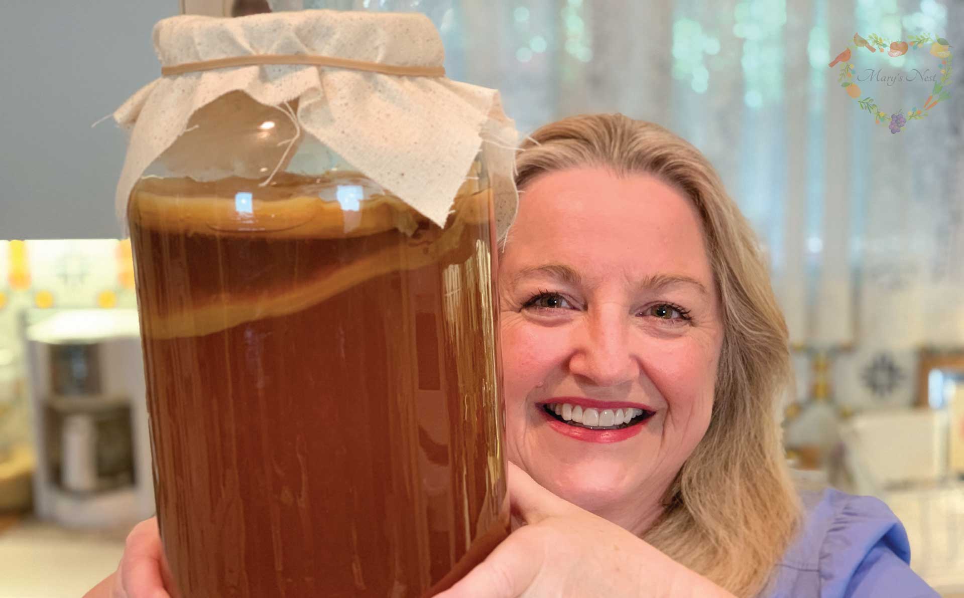 Mary holding a jar with a Kombucha SCOBY.