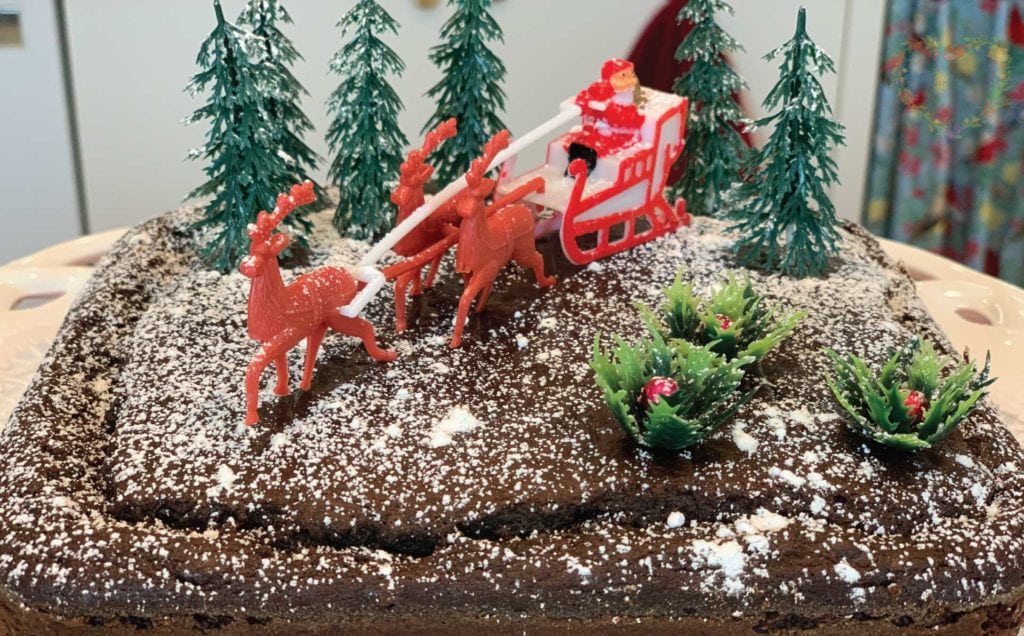 Santa with his reindeer and trees on a gingerbread cake.