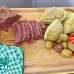 Corned Beef, Cabbage, Potatoes, and carrots on a tray with a St Patricks Day potholder.