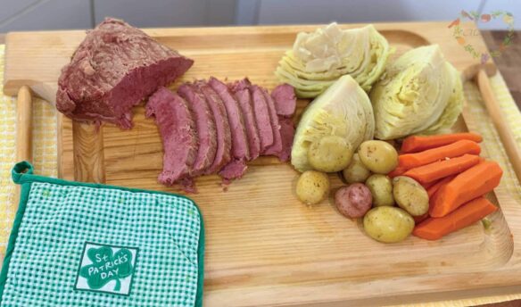 Corned Beef, Cabbage, Potatoes, and carrots on a tray with a St Patricks Day potholder.
