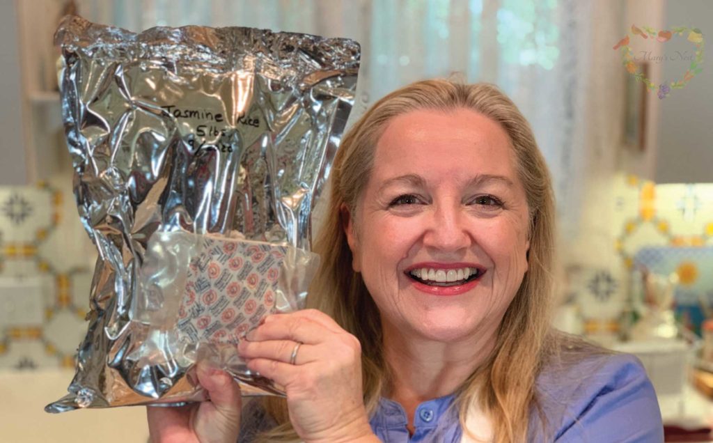 Mary holding a sealed mylar bag and package of oxygen absorbers.