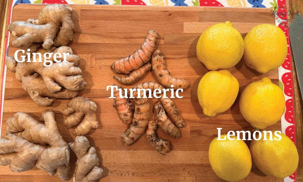Cutting board showing ginger, turmeric, and lemons.
