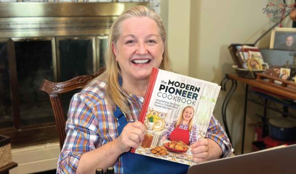 Mary holding The Modern Pioneer Cookbook