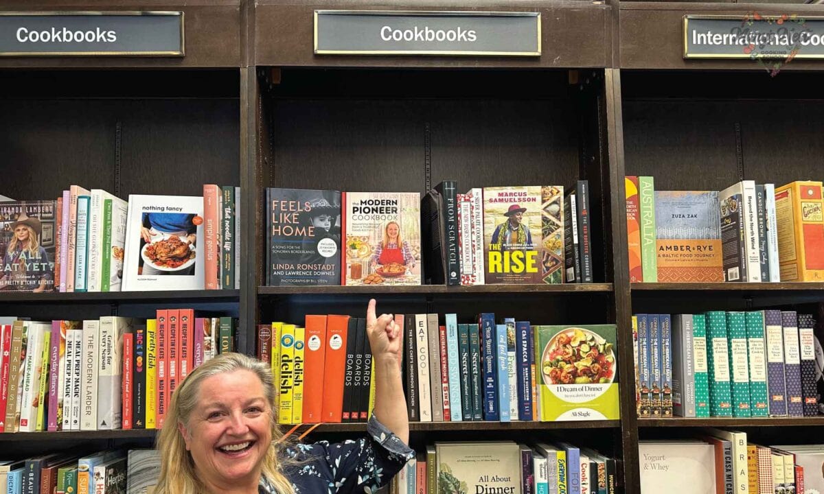 Mary pointing at her cookbook on the shelves at Barnes and Noble.